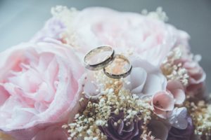 Pour les noces d'argent, deux bagues posées sur un bouquet de fleur.