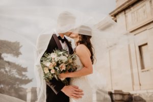 Pour représenter les noces d'Étain, un couple en tenue de marié se faisant un bisou et étant entrelacé se protégeant comme l'Étain protège le fer.
