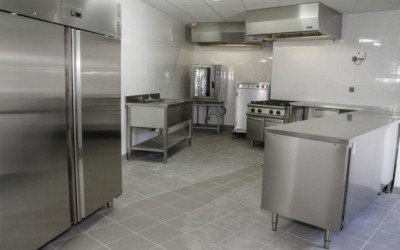 armoire frigorifique, plans de travail inox, four, étuve dans cuisine professionnelle